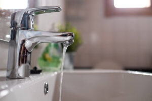 Trickle of water coming out of kitchen sink faucet.