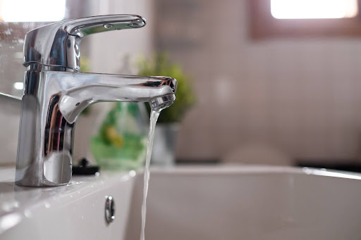 Trickle of water coming out of kitchen sink faucet.