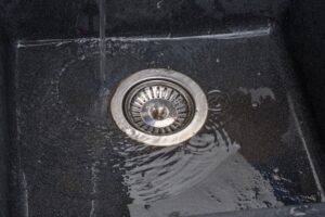 Standing water on top of clogged drain.