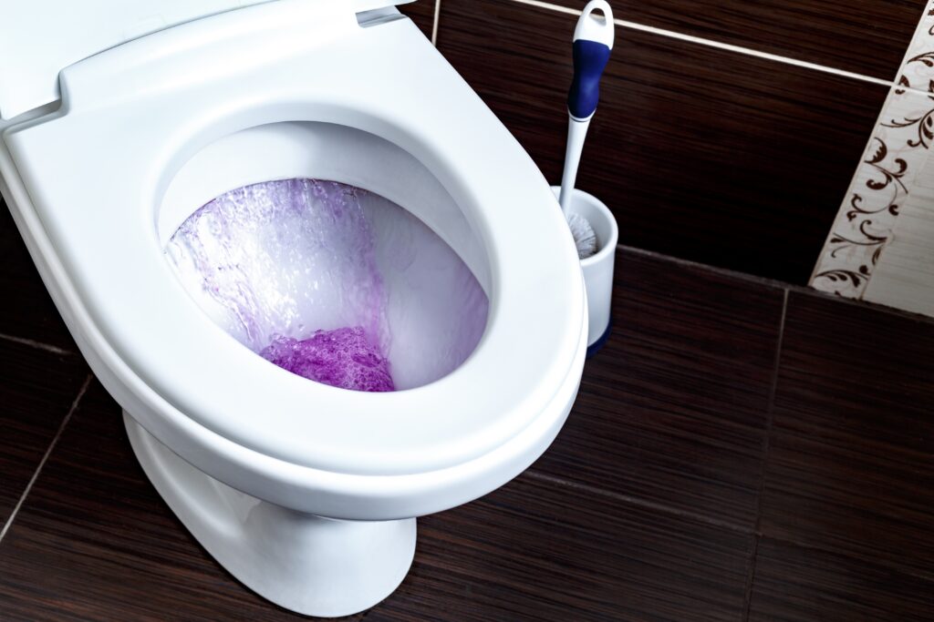 Toilet flushing purple water.